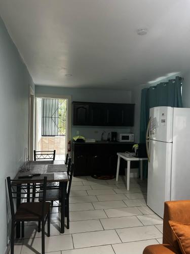 a kitchen with a table and a white refrigerator at Casa Tabacon cr in Río Claro