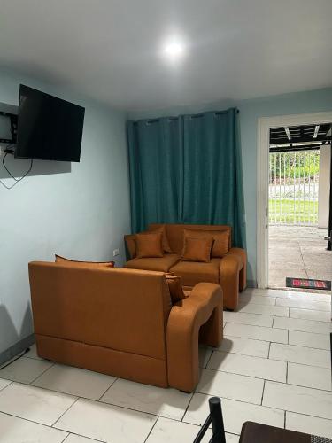 a living room with a couch and a flat screen tv at Casa Tabacon cr in Río Claro