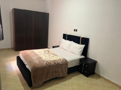 een slaapkamer met een groot bed met een zwart hoofdeinde bij Appartement 2 en rez-de-chaussée in Oujda