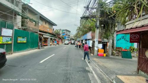 a man walking down a street in a city at Kochimoto Guesthouse in Baguio