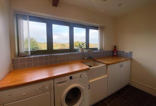 a kitchen with a washing machine and a window at East Lodge in Bedale