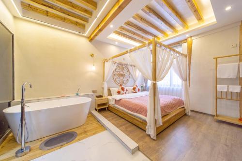 a bathroom with a bed and a tub in a room at GeGeHouse - Lijiang Old Town in Lijiang