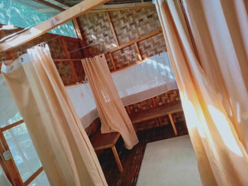 an attic room with curtains and a window at Wellness & Fitness In Life La Union Postural & Joint Alignment Yoga Retreat Yoga Session Center 