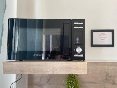 a microwave sitting on top of a wooden shelf at Kleines Apartment in Marl WG 2 in Marl