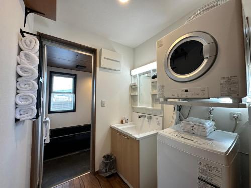 uma pequena casa de banho com uma máquina de lavar roupa e uma máquina de lavar roupa em 21 ORIYA Mt Fuji -縁ENISHI- em Fujikawaguchiko
