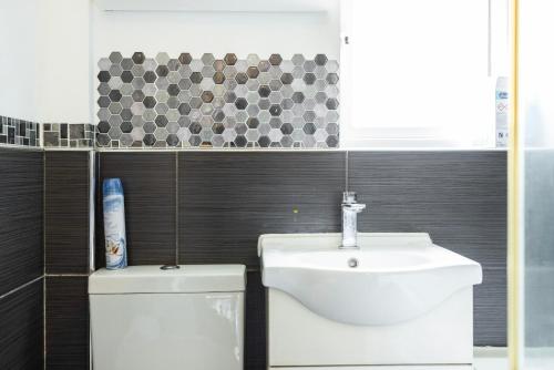 a bathroom with a toilet and a sink at Heads on Bed - Dagenham 3Bedrooms House walk to Station with Parking in Dagenham
