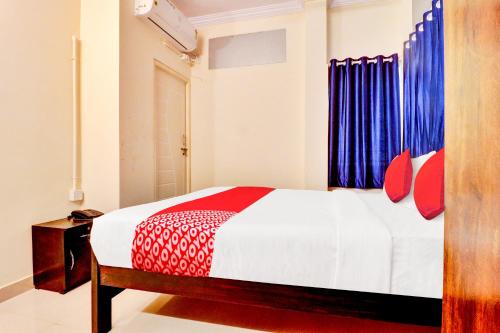 a bedroom with a bed with red and blue curtains at Hotel O IRA Comforts in Bengaluru