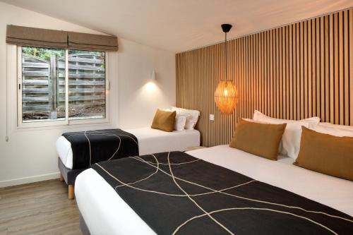 a hotel room with two beds and a window at Hôtel & Spa Les Mouettes in Argelès-sur-Mer