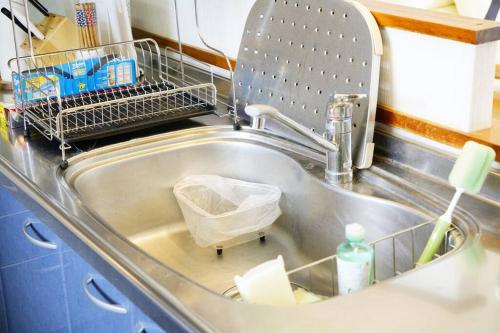 a kitchen sink with a dish drying rack in it at 【駐車場4台！】都会の喧騒から離れ大自然に囲まれた豪邸～大石林山への観光にも最適～ in Kunigami