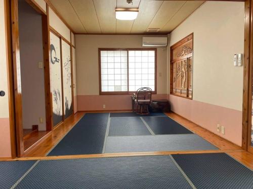 an empty room with blue mats on the floor at 【駐車場4台！】都会の喧騒から離れ大自然に囲まれた豪邸～大石林山への観光にも最適～ in Kunigami