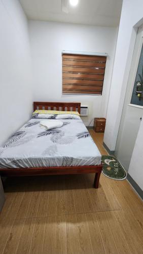 Schlafzimmer mit einem Bett mit einem Kopfteil aus Holz in der Unterkunft DJK Guest House in Pooc