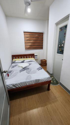 Schlafzimmer mit einem Bett mit einem Kopfteil aus Holz in der Unterkunft DJK Guest House in Pooc