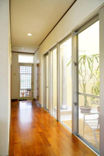 an empty room with a hallway with sliding glass doors at 【駐車場4台！】都会の喧騒から離れ大自然に囲まれた豪邸～大石林山への観光にも最適～ in Kunigami