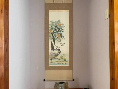 a painting of a tree on a white wall at 【駐車場4台！】都会の喧騒から離れ大自然に囲まれた豪邸～大石林山への観光にも最適～ in Kunigami