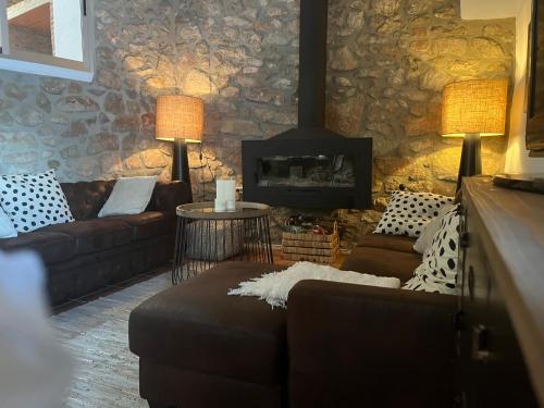 a living room with a couch and a fireplace at Casa Rural La Garcia in Puebla de Arenoso