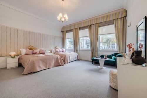 - une grande chambre avec 2 lits et un canapé dans l'établissement Harley Street Spectacular Suites with High Ceilings, High Luxury, à Londres