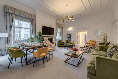 een woonkamer met een bank en tafels en stoelen bij Harley Street Spectacular Suites with High Ceilings, High Luxury in Londen