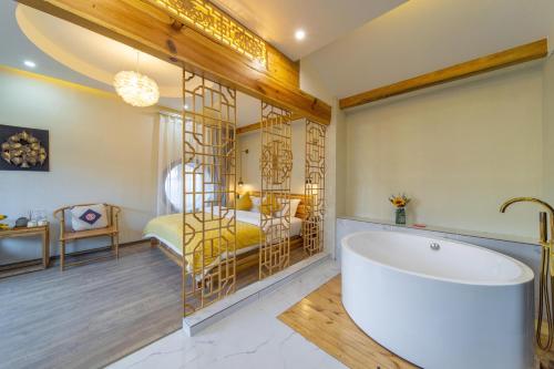 a bathroom with a large tub and a bedroom at Gegewu Inn - Lijiang Ancient Town in Lijiang