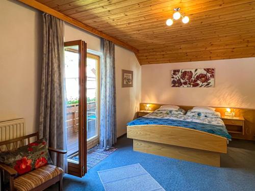 Schlafzimmer mit einem Bett und einem Fenster in der Unterkunft Ferienwohnungen am See Haus Spitzer in Keutschach am See
