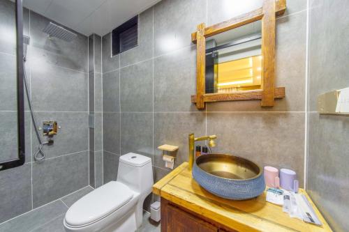 a bathroom with a sink and a toilet and a mirror at GeGeHouse - Lijiang Old Town in Lijiang