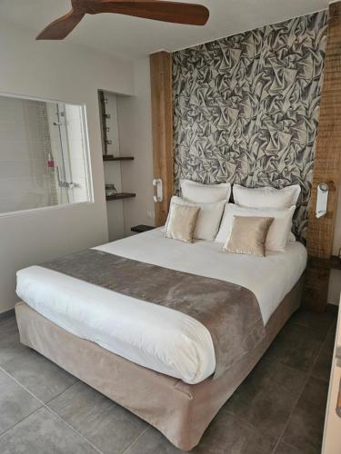 a bedroom with a large bed with a wall at Les Secrets du Défends in Forcalqueiret