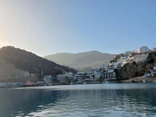 a town on a hill next to a body of water at Happy Days in Agia Galini