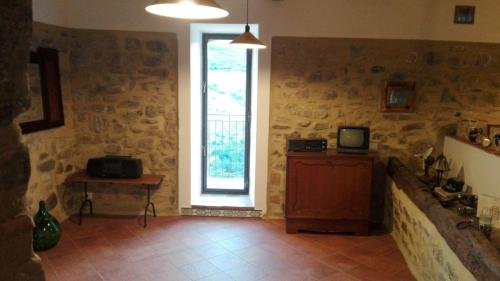 a room with a window and a tv on a wall at Giro di vite in Rocca Imperiale