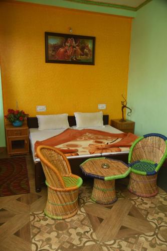 um quarto com uma cama com 2 cadeiras e uma mesa em DWARIKA HOTEL em Dwārāhāt