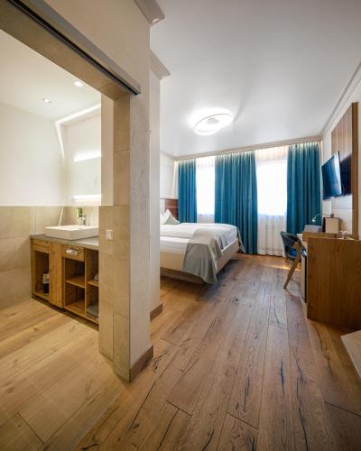 a bedroom with a bed and a bathroom with a sink at Design Hotel Frauenschuh in Salzburg