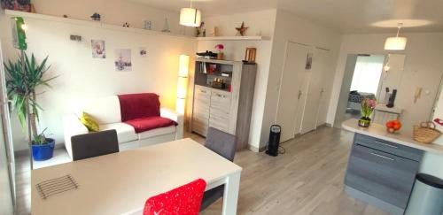 a small living room with a table and a couch at Appartement calme rez-de-jardin in Saint-Étienne