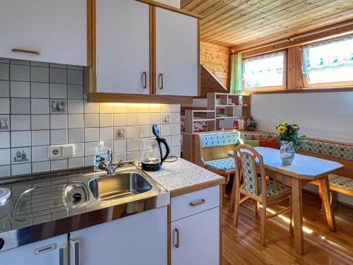 eine Küche mit einem Waschbecken und einem Tisch in der Unterkunft Ferienwohnungen am See Haus Spitzer in Keutschach am See