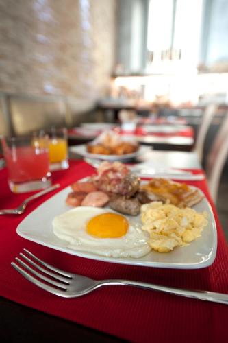 a plate of breakfast food on a red table at Hotel Five in Milan