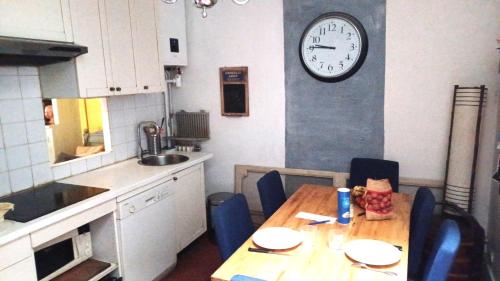 une cuisine avec une table et une horloge au mur dans l'établissement Marceau, à Paris