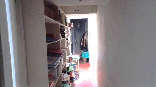 un couloir avec une pièce remplie de livres dans l'établissement Marceau, à Paris