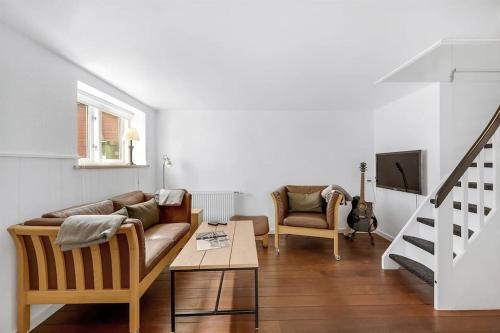 a living room with a couch and a table at Nyd den skønne natur ved hav og fjord in Thyborøn