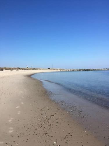 a beach with the ocean and the shoreline at Nyd den skønne natur ved hav og fjord in Thyborøn