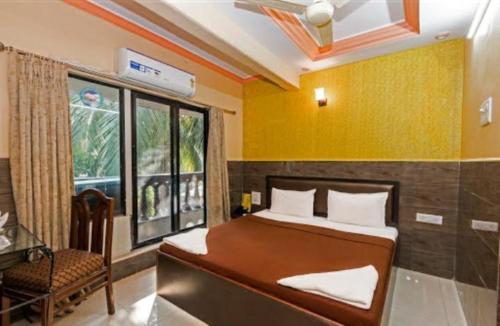 a bedroom with a bed and a chair and a window at Hotel classic residency in Mumbai