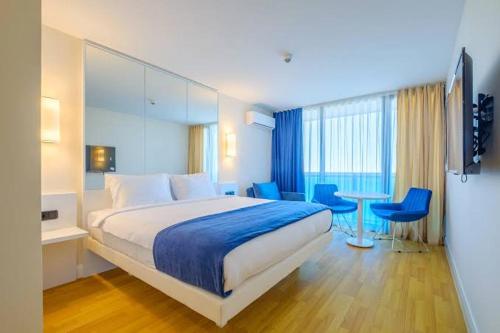 um quarto de hotel com uma cama, uma mesa e cadeiras em Seturan Apartment em Seturan