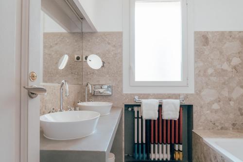 a bathroom with two sinks and a mirror at Ermitage de l'Oasis & Spa - Cannes Mandelieu in Mandelieu-la-Napoule