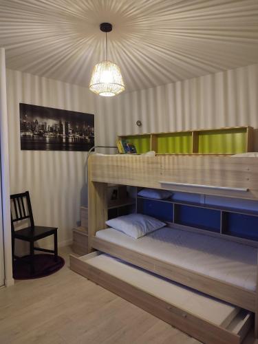 - une chambre avec des lits superposés et un lustre dans l'établissement Ma Pause Normande T3 Les Isles de Sola, à Grandcamp-Maisy