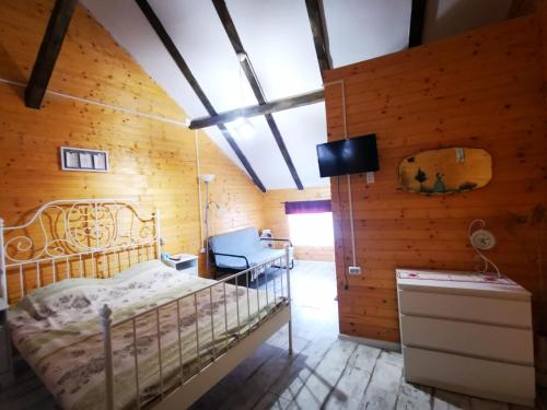 1 dormitorio con 1 cama en una habitación con paredes de madera en Casa de Oaspeti Dunarea la Cazane, en Dubova