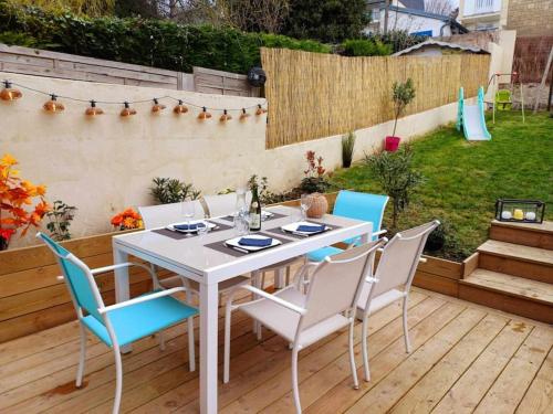 - une table et des chaises blanches sur la terrasse dans l'établissement Maison de vacances familiale à Trouville-sur-mer, à Trouville-sur-Mer