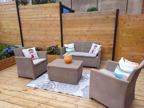 eine Terrasse mit 3 Korbstühlen und einem Tisch in der Unterkunft Maison de vacances familiale à Trouville-sur-mer in Trouville-sur-Mer