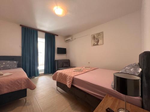a hotel room with two beds and a chair at Guesthouse Civovic in Bar