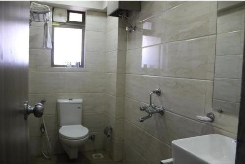 a bathroom with a toilet and a sink and a shower at Hotel classic residency in Mumbai