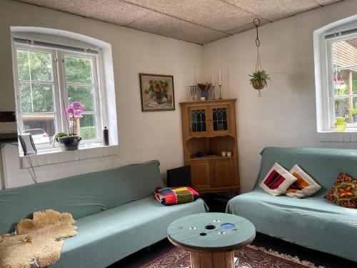 a living room with two green couches and a table at Mormors Stue - Grethelund in Silkeborg