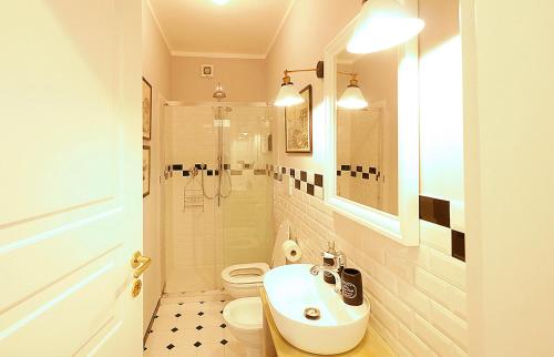 a bathroom with a toilet and a sink and a shower at Appartamento La Stazione in Donoratico