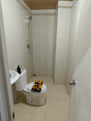 a bathroom with a shower and a toilet and a sink at Jogja Amor Hotel in Demangan