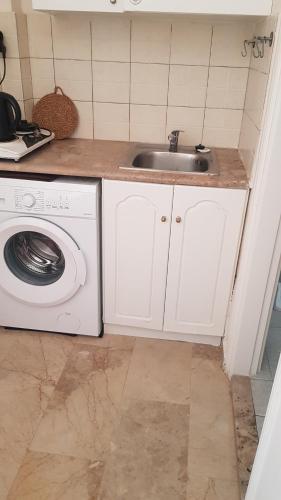 uma cozinha com um lavatório e uma máquina de lavar roupa em Melina's Sunset em Myrties