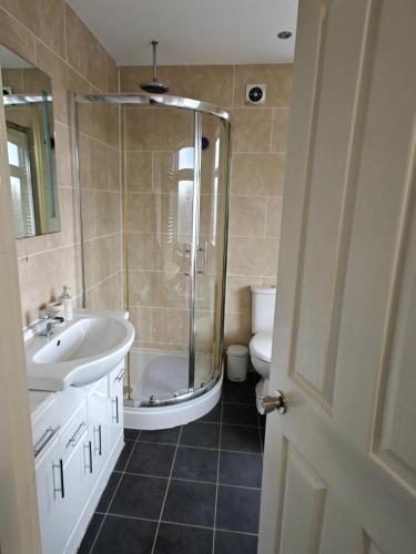 a bathroom with a shower and a sink and a toilet at Under 10 Mins to NEC BHX - Walk to JLR -2 Large Living Areas - 4 Bedroom Spacious Home - Van Parking x2 - 5 Beds Excellent Equipped Home - NR A45 Solihull Bypass M42 HS2 Works in Solihull